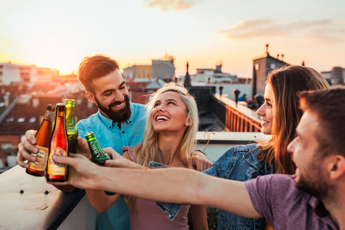 Gruppe Menschen in der Stadt stossen mit Bier an